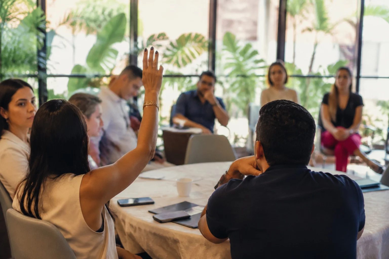 Estudante levantando a mão em uma mesa de seminário coberta de anotações